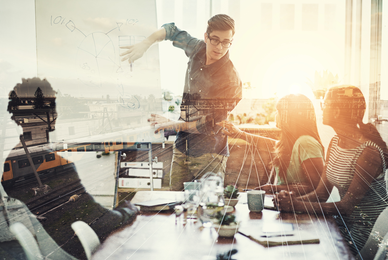 Multiple exposure shot of a business group superimposed over a train track